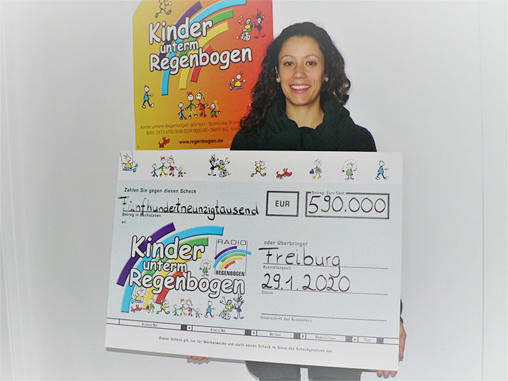 Julia Rabe erhält den Spendenscheck der Aktion Kinder unterm Regenbogen